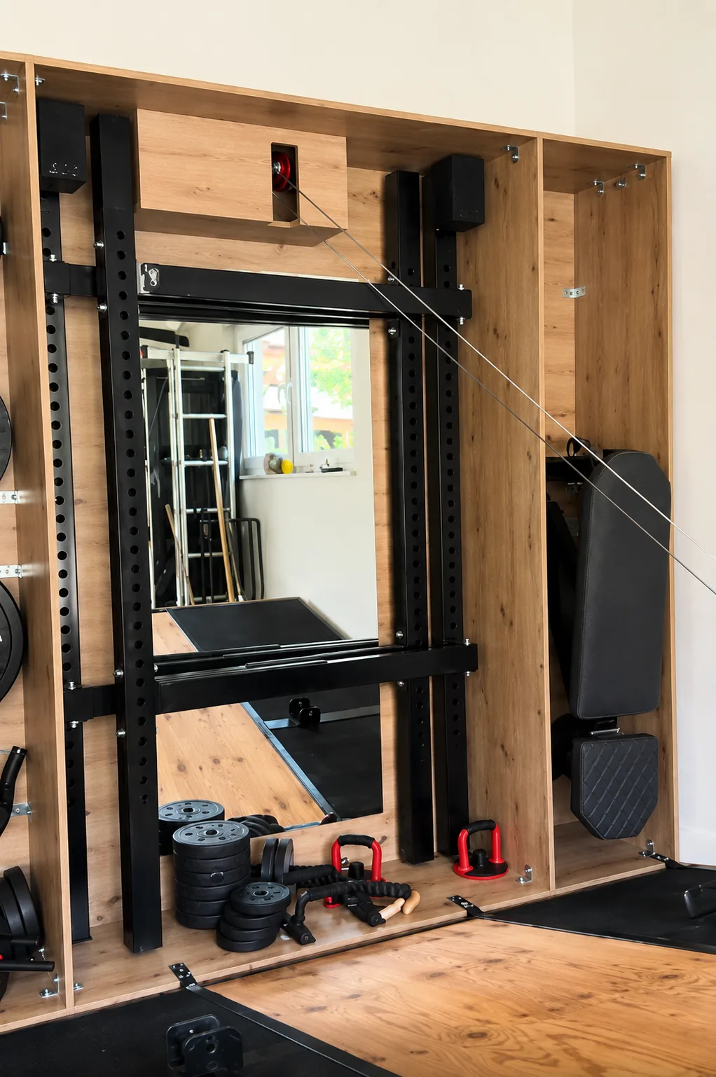 Otvoren Secret Gym ormar — stalak za čučnjeve, zrcalo, klupa i olimpijski utezi.